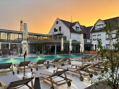 Garten Neu Außenansicht des Hotel Nationalpark mit beheiztem Außenpool, Liegeterrasse und modernem Hotelgebäude in der Abendsonne.