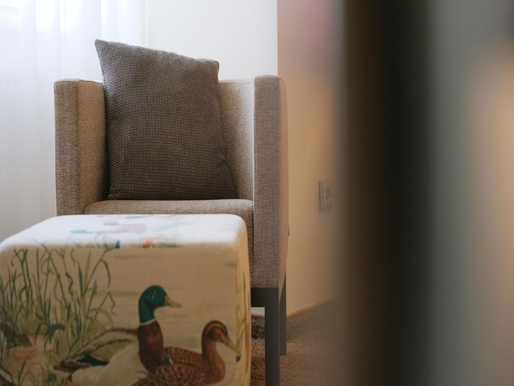 Sitzmöbel mit dekorativem Kissen im ruhigen Zimmerbereich