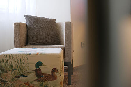 Sitzmöbel mit dekorativem Kissen im ruhigen Zimmerbereich