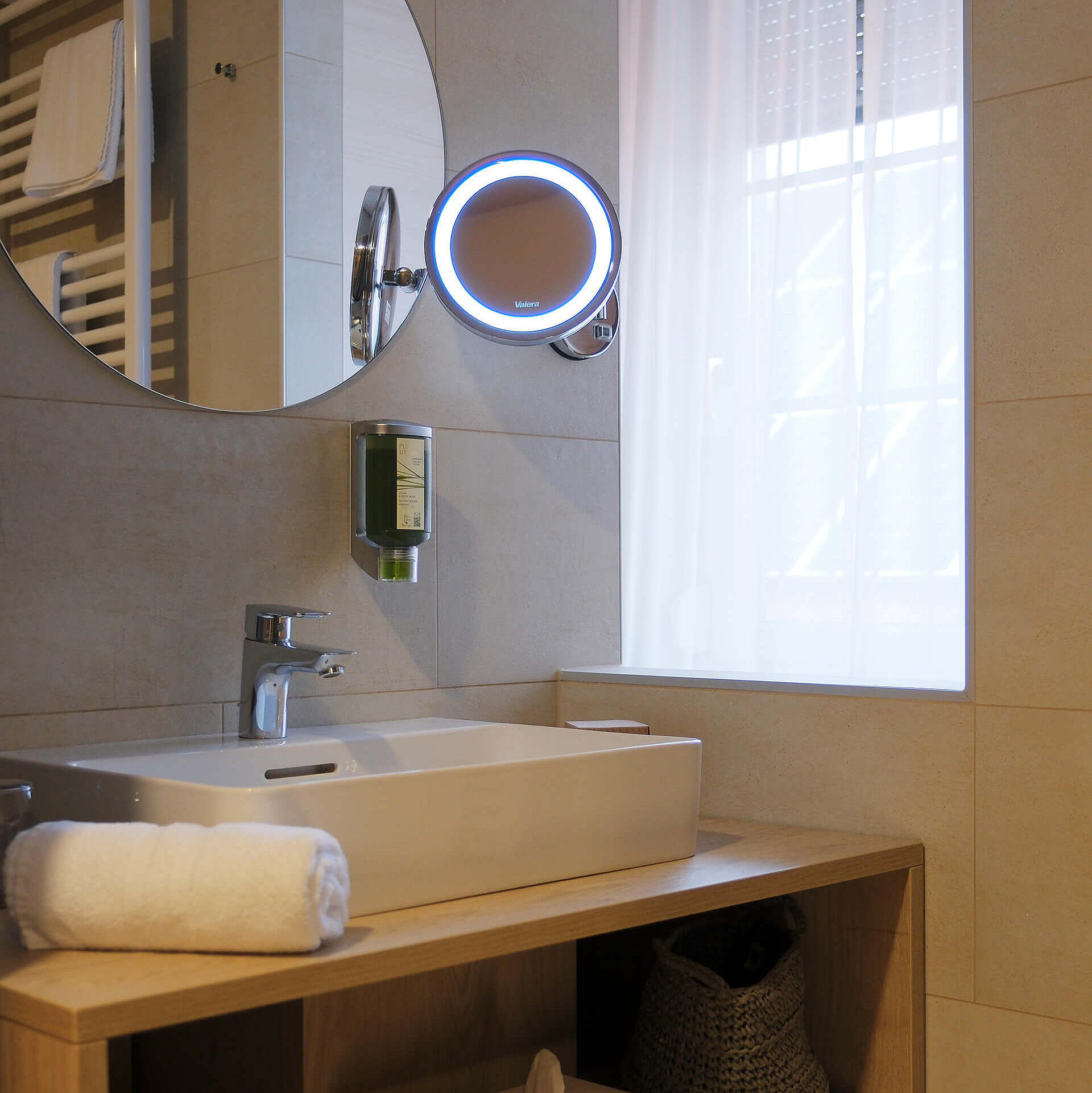 Modernes Badezimmer mit Waschbecken, Spiegel und Stauraum