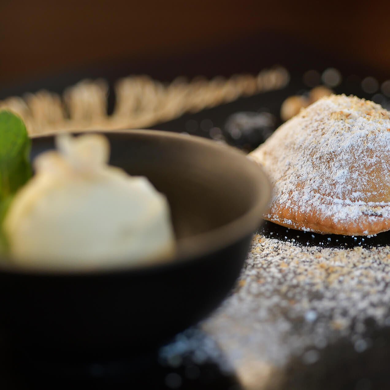 Balasn mit Staubzucker, serviert mit einer Kugel Eis.
