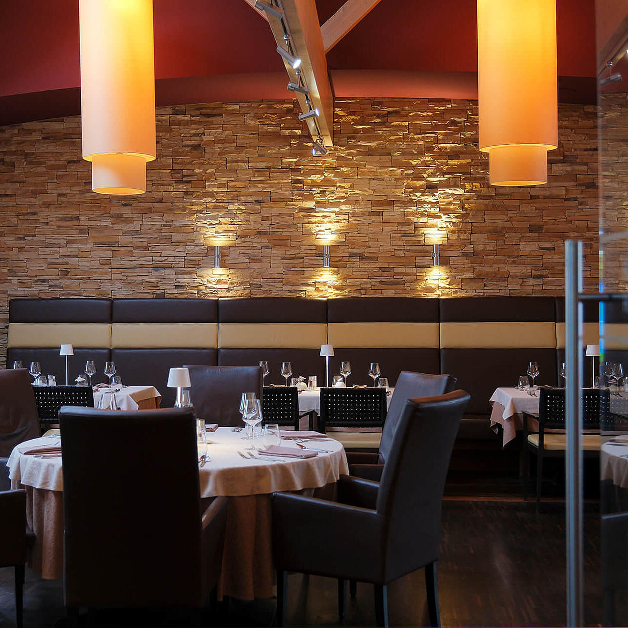 Modernes Restaurant mit gedeckten Tischen, warmem Licht und stilvollem Interieur