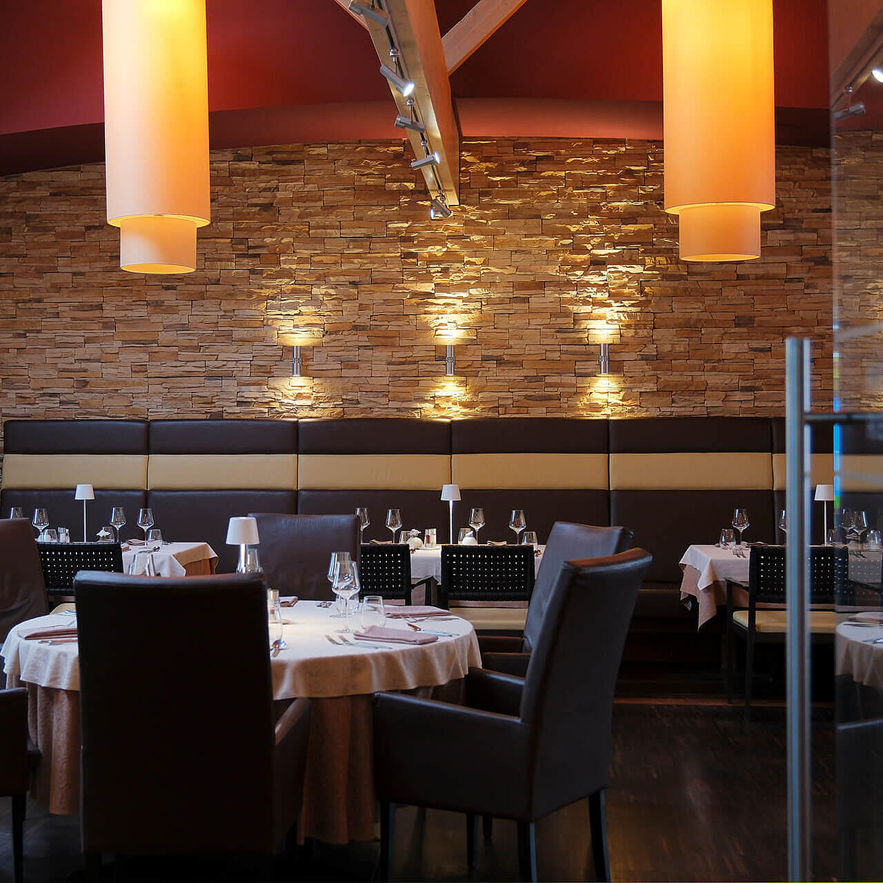 Modernes Restaurant mit gedeckten Tischen, warmem Licht und stilvollem Interieur