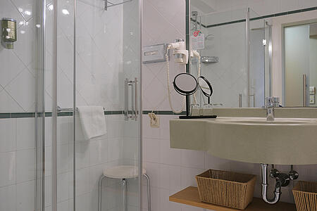 Modernes Badezimmer mit Dusche, Waschbecken und Spiegel