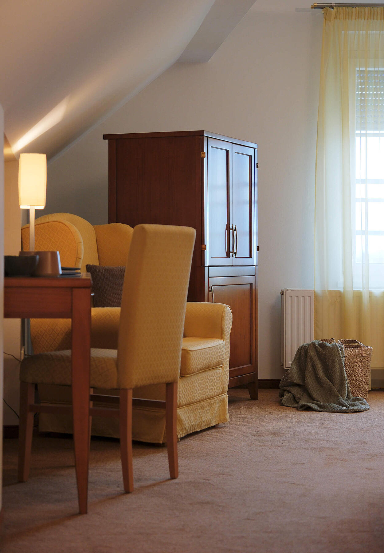 Sitzbereich mit Sessel, Tisch und Fenster im hellen Zimmer