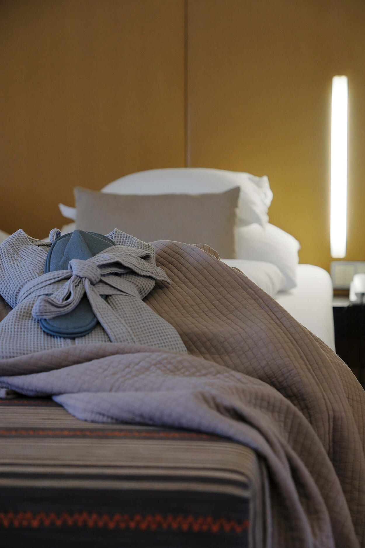 Detailansicht des Bettes mit Decken und stimmungsvoller Beleuchtung