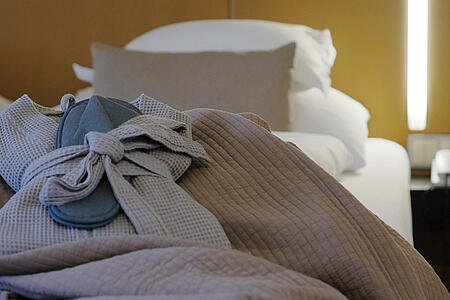 Detailansicht des Bettes mit Decken und stimmungsvoller Beleuchtung