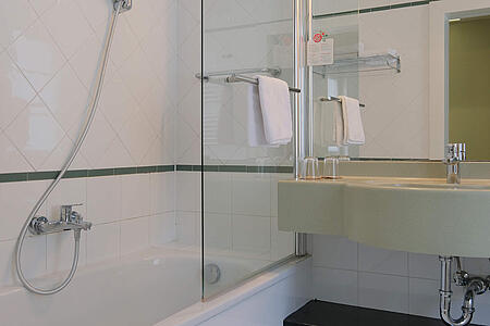 Modernes Badezimmer mit Badewanne, Dusche und Glasabtrennung