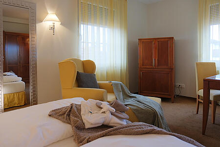 Doppelzimmer mit großem Bett, Sitzbereich und warmer Beleuchtung