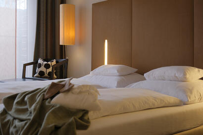 Doppelzimmer mit großem Bett, warmem Licht und Blick zur Gartenterrasse