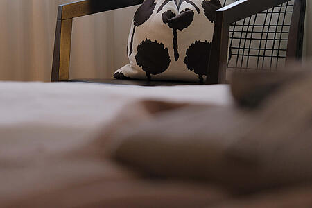 Detailansicht eines Kissens mit Muster auf dem Bett im hellen Zimmer