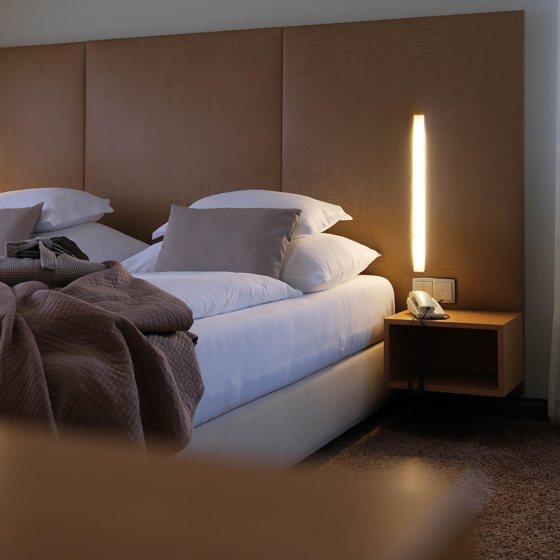 Detailansicht des Bettes mit Nachttisch und moderner Stehleuchte