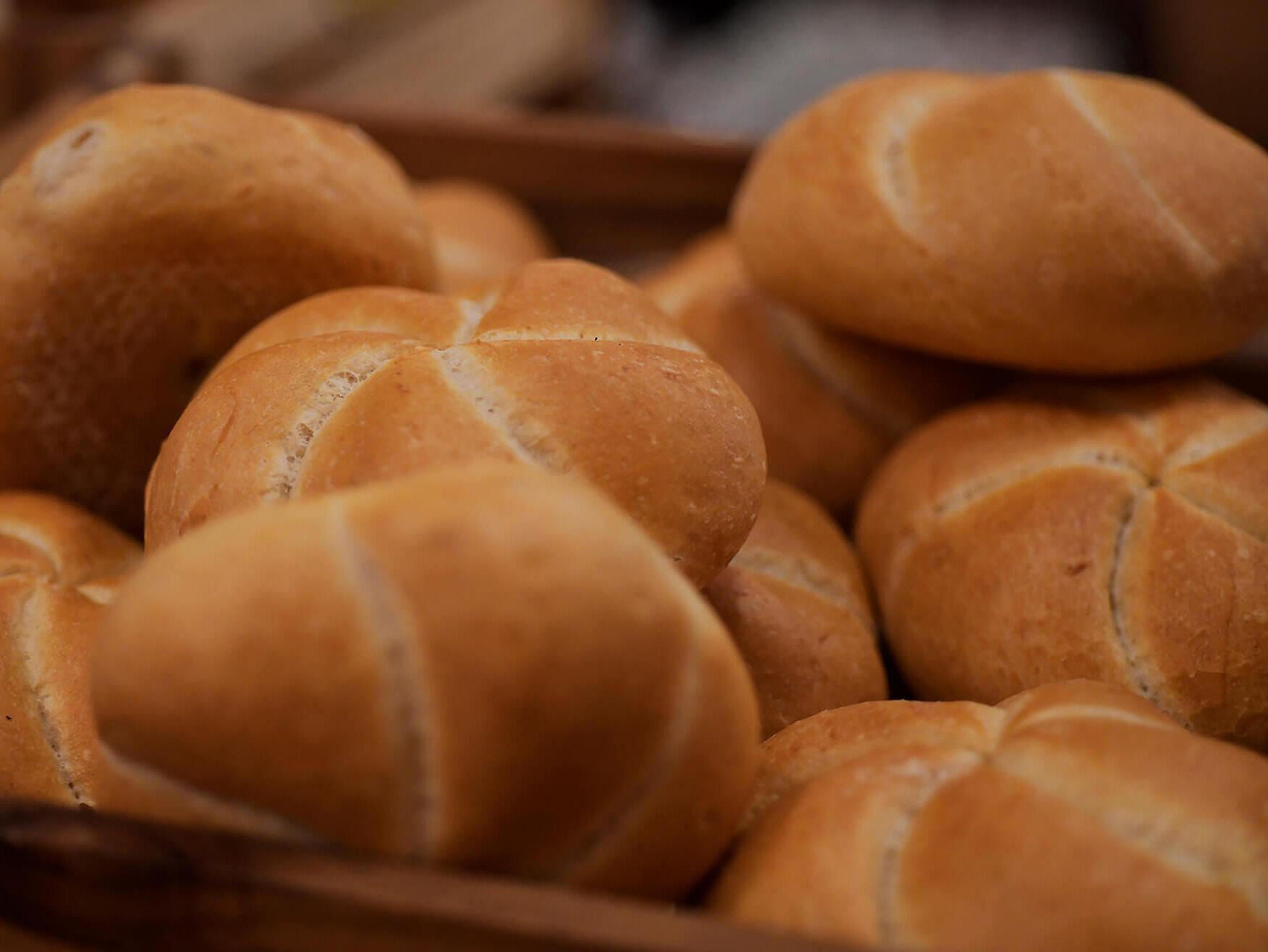 Frische Semmeln liegen in einem Korb am Frühstücksbuffet.