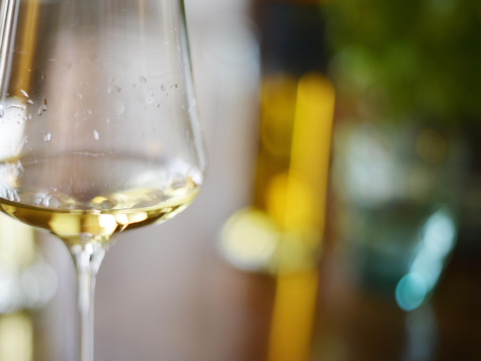 Weinglas mit Weißwein im warmen Licht