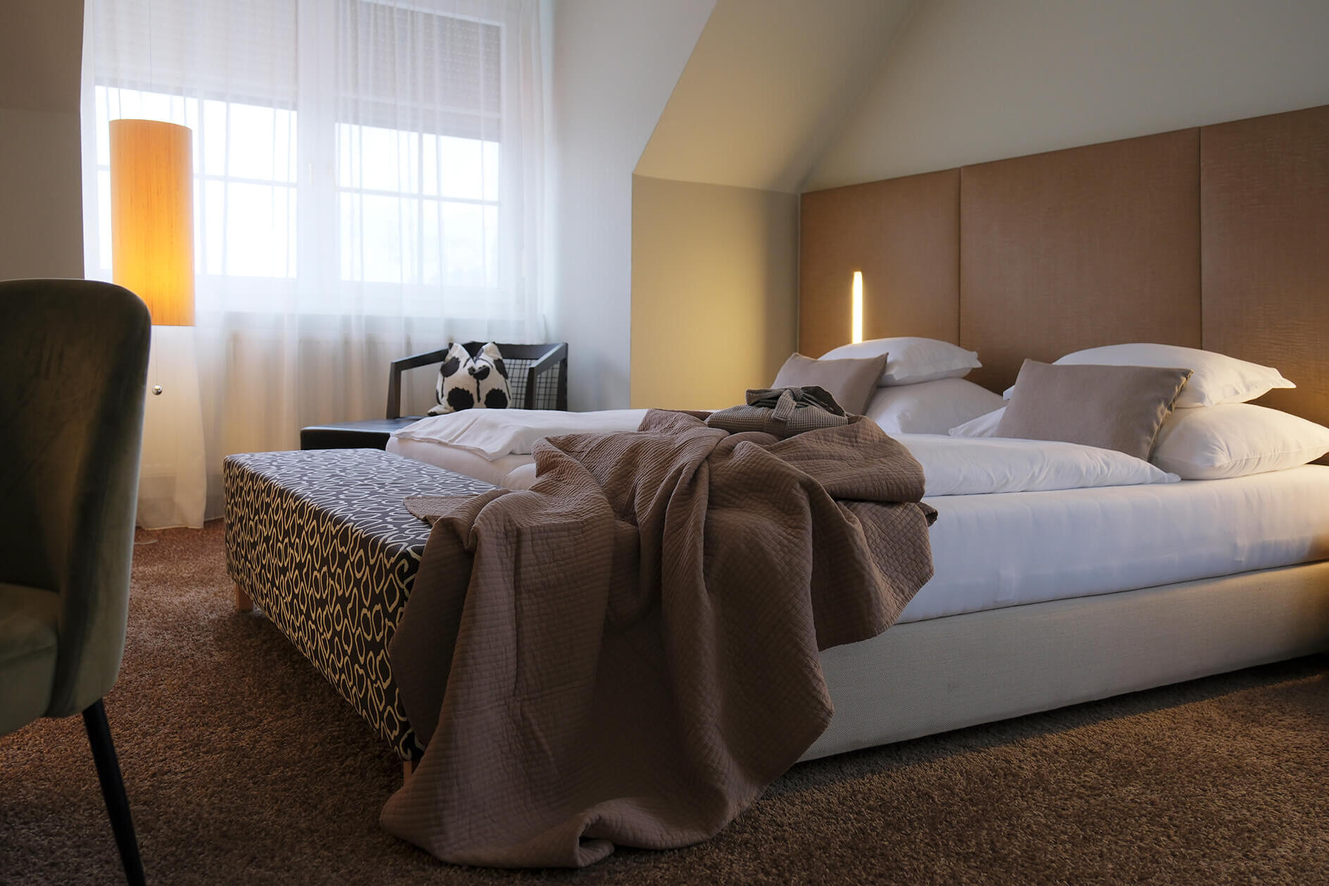 Doppelzimmer mit großem Bett, Decken und Fenster mit Tageslicht