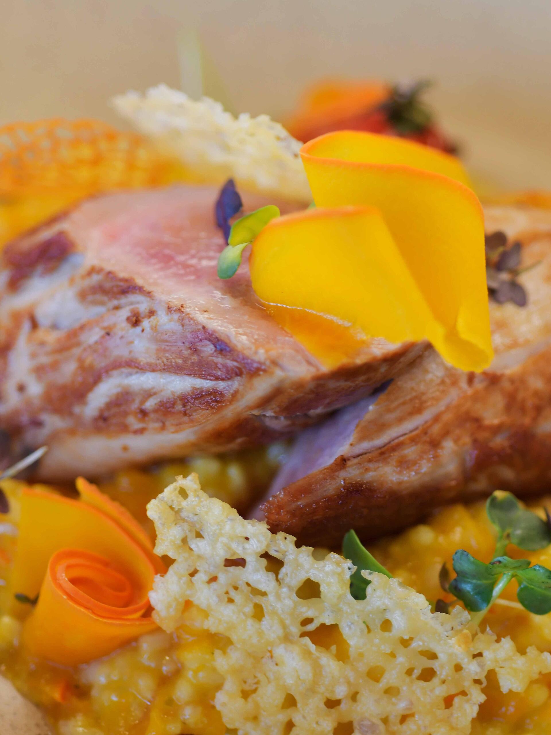 Fein angerichtetes Gericht mit Fleisch und Gemüse auf einem Teller.