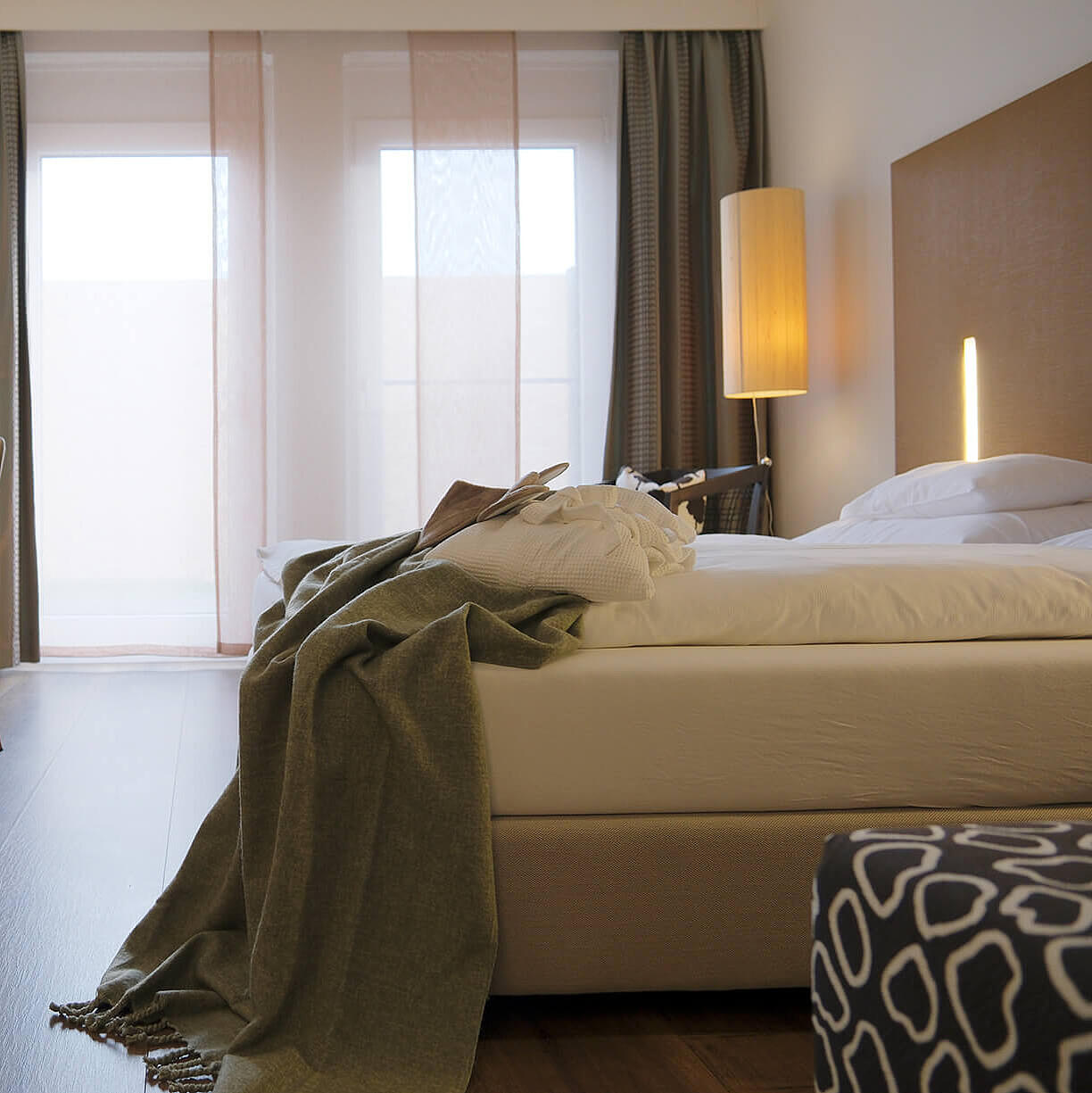 Modernes Doppelzimmer mit Bett, Stauraum und Zugang zur Gartenterrasse